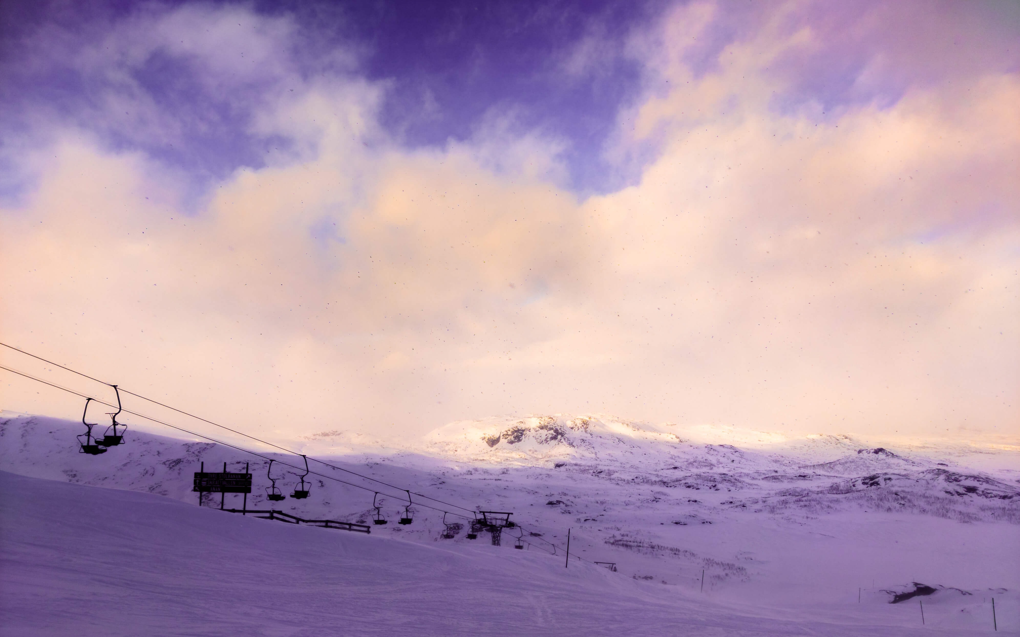 Luminen maisema vuoristossa. Hiihtohissi kuvassa taustalla